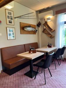 a restaurant with two tables and chairs and a fish on the wall at Overhalla Hotel in Overhalla 
