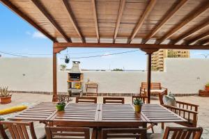 a wooden table and chairs on a patio with a grill at Rincón de Daute in Los Silos