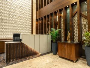 an office lobby with a desk and potted plants at Taika Hotels, 1km Away from Main Temple in Rāmeswaram