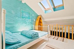 a bed in a room with a blue wall at Apartament Pescăruș in Schitul