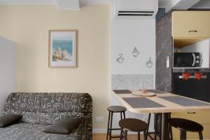 a kitchen with a table and chairs and a couch at O'soleil in Fréjus