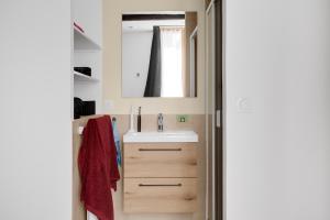 a bathroom with a sink and a mirror at O'soleil in Fréjus +10 photos