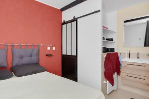 a bedroom with a white bed and a red wall at O'soleil in Fréjus