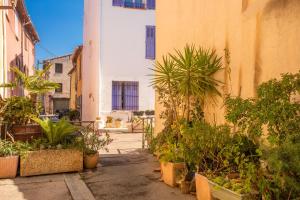 an alley with potted plants and a building at O'soleil in Fréjus