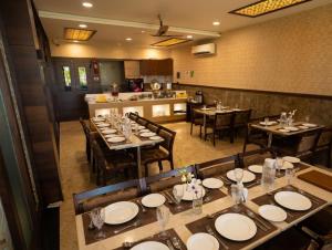 a restaurant with tables and chairs and a kitchen at Taika Hotels, 1km Away from Main Temple in Rāmeswaram