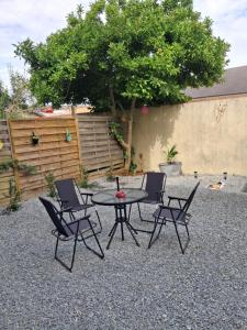 a patio with a table and chairs and a tree at côté gare in Dreux
