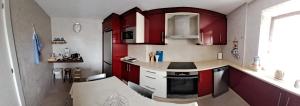 a kitchen with red cabinets and a counter top at MERAKI in Fisterra