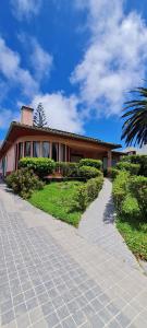 a house with a palm tree in front of a driveway at Casa Carmen in Cabouco
