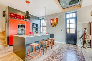 a kitchen with an island with bar stools at Gîte des Ducs de Guise - vue sur le Château fort in Guise +10 photos