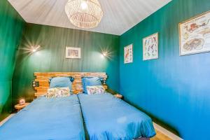 a bedroom with blue and green walls and a bed at Gîte des Ducs de Guise - vue sur le Château fort in Guise