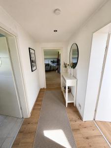 a hallway with white walls and a mirror and a rug at Alpzeit Ferienwohnung in Bayerisch Gmain