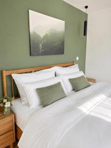 a large bed with white sheets and green walls at Alpzeit Ferienwohnung in Bayerisch Gmain