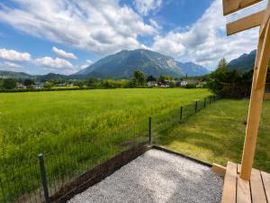 a fence in front of a field with a mountain at Alpzeit Ferienwohnung in Bayerisch Gmain