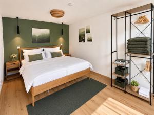a bedroom with a bed and a green wall at Alpzeit Ferienwohnung in Bayerisch Gmain