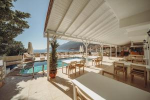 un patio con mesas y sillas y una piscina en Arpia Hotel, en Kas