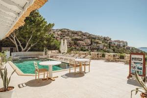 un complejo turístico con piscina, mesas y sillas en Arpia Hotel, en Kas