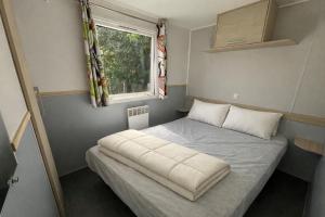 a small bed in a small room with a window at Camping La Sensation in Matringhem +50 photos