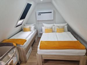 two twin beds in a attic room with at VilaMi Ferienwohnung mit Indoor Pool, Sauna, Hunde willkommen in Schönwald +33 photos