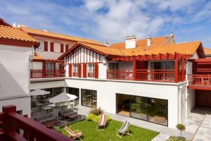 an exterior view of a house with a patio at Hôtel Kemaris in Biarritz