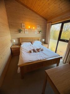 a woman laying on a bed in a room at Luxury Woodland Lodge near Clovelly & Bude in Woolfardisworthy