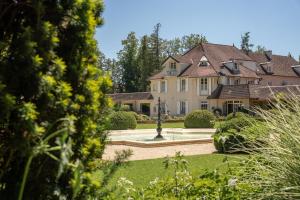 a large house with a fountain in a yard at Hostellerie De Levernois in Levernois