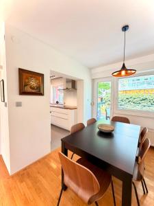 a dining room with a black table and chairs at Central Townhouse with Parking in Ljubljana +5 photos