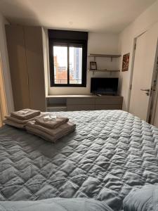 a large bed in a room with a window at EXCLUSIVO PENTHOUSE EN CORDON SOHO con parrillero in Montevideo