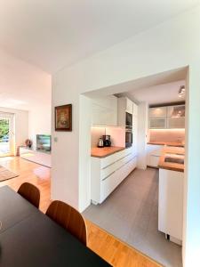 a kitchen with white cabinets and a table at Central Townhouse with Parking in Ljubljana