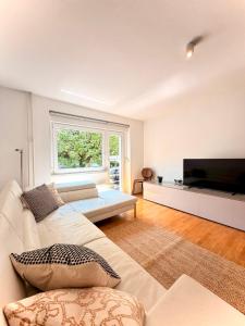 a living room with a couch and a television at Central Townhouse with Parking in Ljubljana
