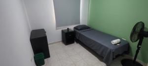 a small bedroom with a bed and a fan at Oasis in Valledupar +4 photos