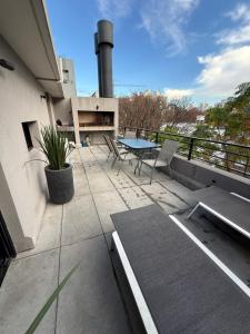a patio with a table and chairs on a building at EXCLUSIVO PENTHOUSE EN CORDON SOHO con parrillero in Montevideo