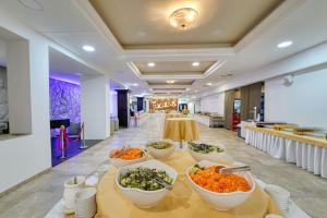 a buffet line with bowls of food on a table at Grand Hotel BELLEVUE in Starý Smokovec