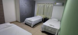 a room with two beds and a mirror at Oasis in Valledupar