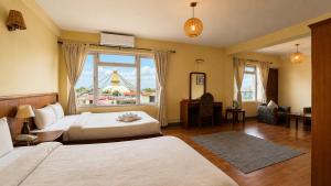 a bedroom with two beds and a large window at Hotel Sherwi Hyul in Kathmandu +33 photos