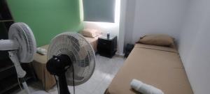 a room with two beds and two fans at Oasis in Valledupar