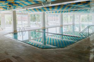 an indoor swimming pool with a pool at HEIMATEL - Rosenalm Scheidegg in Scheidegg