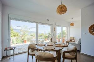 a living room with a table and chairs and a large window at Dimitra Beach Apartments - Thassos Skala Potamias in Skala Potamias