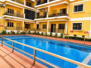 a swimming pool in front of a building at Coconut Sky 2Bhk Penthouse Baga in Baga