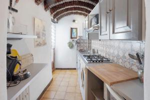 a kitchen with white cabinets and a stove top oven at La Clé de l'Arboux in Mandagout