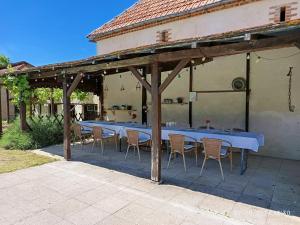 a group of tables and chairs under a pavilion at Gîte Chevannes - Holiday home - Pool - Parking - Mobility friendly - Pets welcome in Fours