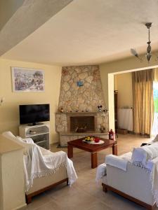 a living room with a fireplace and a tv at Villa Beauty in Paliouri