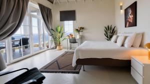 a bedroom with a bed with a view of the ocean at Whale Tails Island Suites & Villas in Oranjestad +60 photos