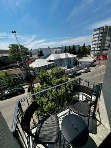 a balcony with two chairs and a table and a street at Central Studio in Piteşti
