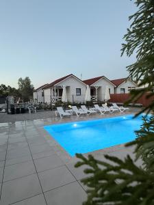 a swimming pool with lounge chairs and a house at Wakacje Bobolin in Bobolin
