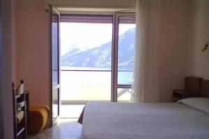 a bedroom with a bed and a large window at Hotel Glavjc in Torno