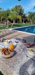 a table with food and drinks on a table near a pool at Palm Suites Algarve in Portimão