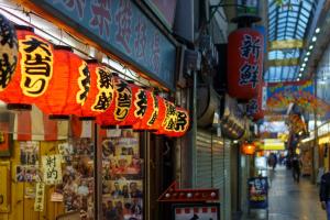 eine Straße mit Schildern an der Seite eines Gebäudes in der Unterkunft OKINI - Doyanen Hotels in Osaka