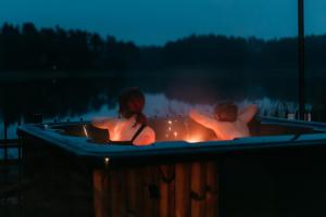 two people sitting in a bathtub with a fire at Augustów Willa Sóweczka in Sucha Rzeczka