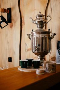 a tea kettle and three cups on a table at Augustów Willa Sóweczka in Sucha Rzeczka +22 photos