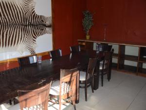 a dining room with a black table and chairs at Oluzizi Guesthouse in Windhoek